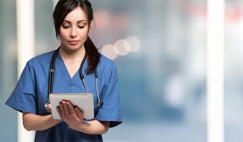nurse using a tablet to access patient's medical information