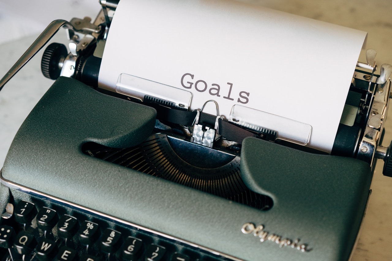 typewriter with paper that says goals
