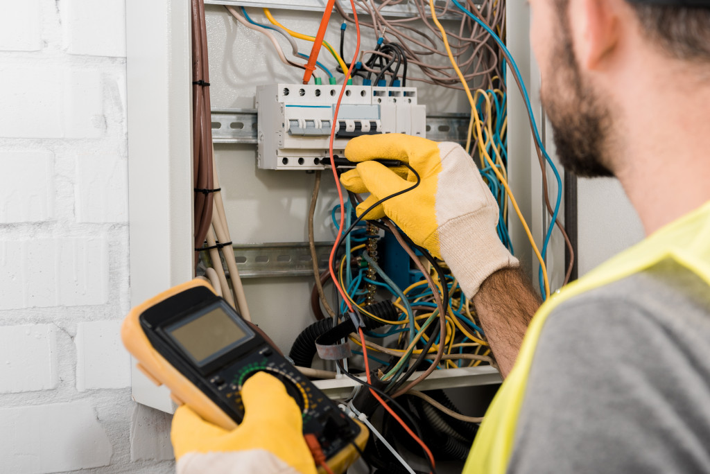 man inspecting electrical wirings