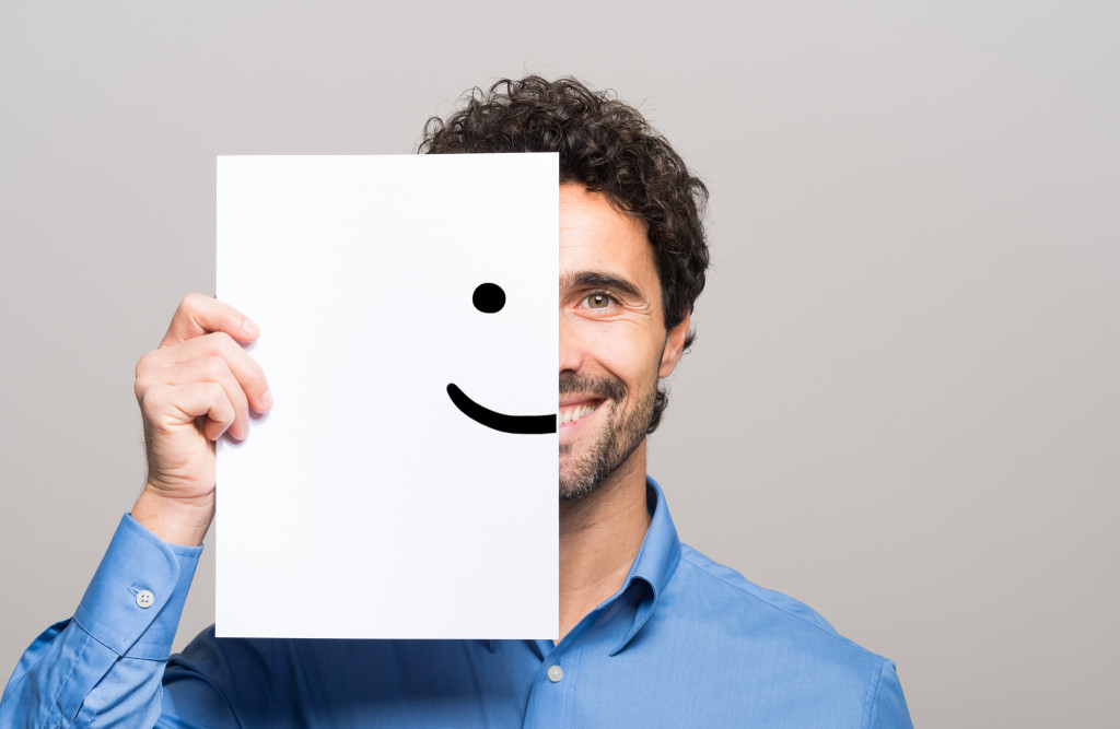 person holding a cardboard with a smiley