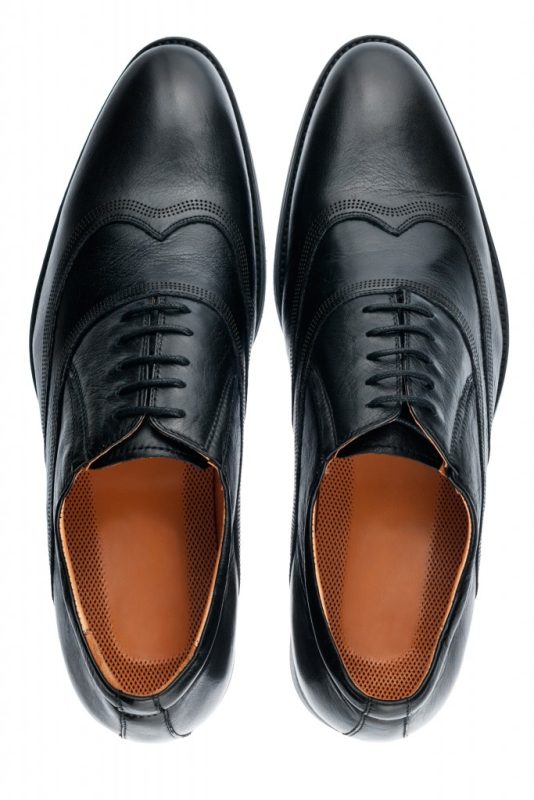 Classic male black leather shoes isolated on a white, top view