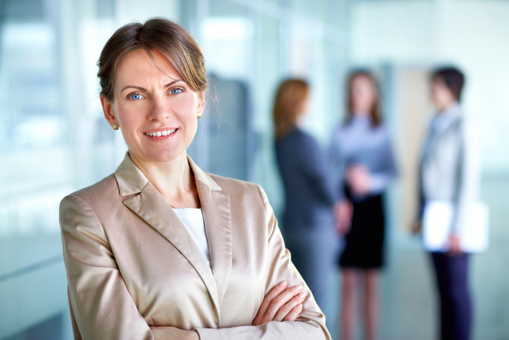 a female boss smiling with some employees in the background