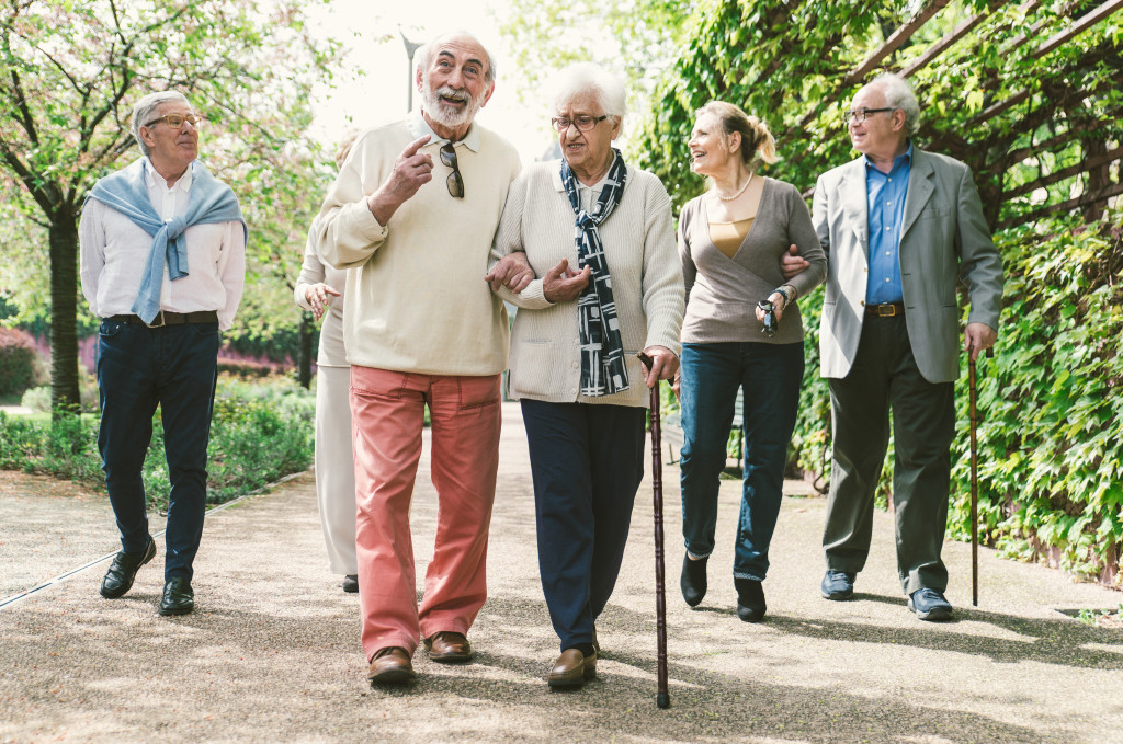 a group of elderly walking with some using a cane for assistance