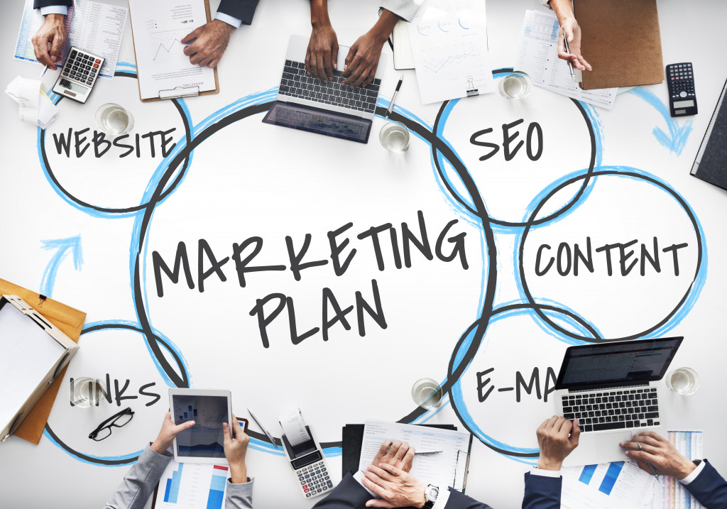 A marketing plan chart with professionals surrounding it