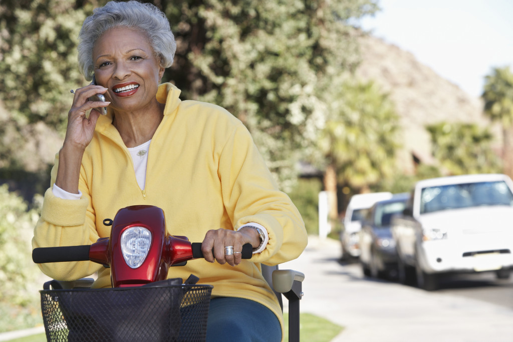 an elderly woman on a electric scooter talking on a cellphone