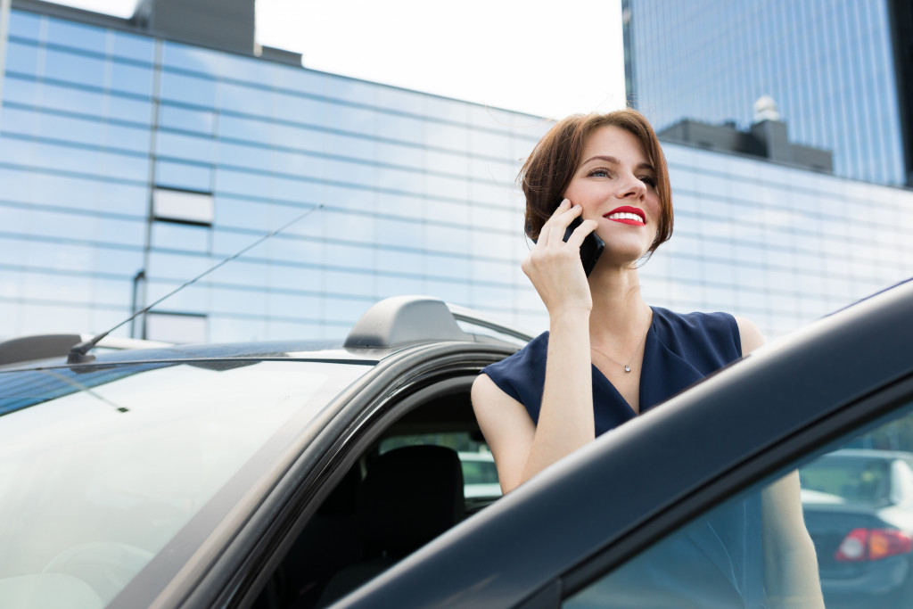business woman on phone getting in her car