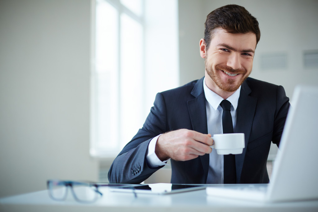 man holding a mug smiling