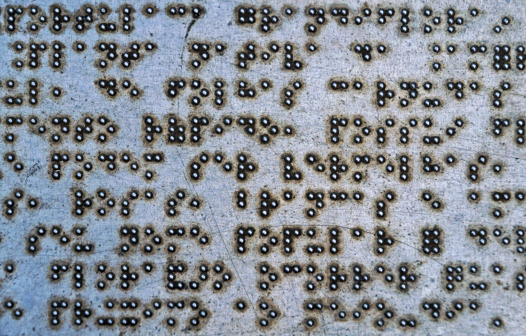 Braille letters on flat metal plate