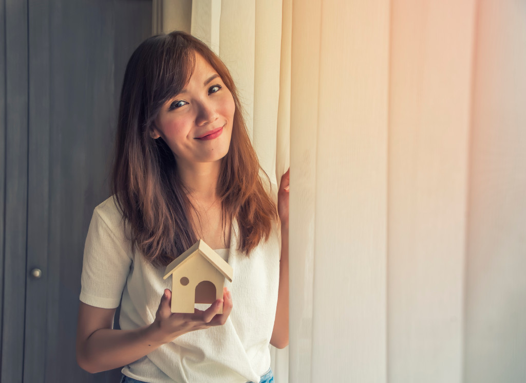 woman holding a mini house