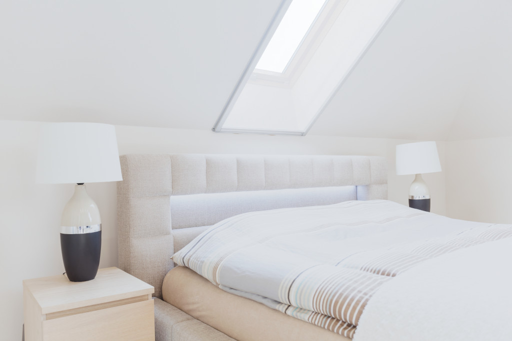 A skylight over a big white bed