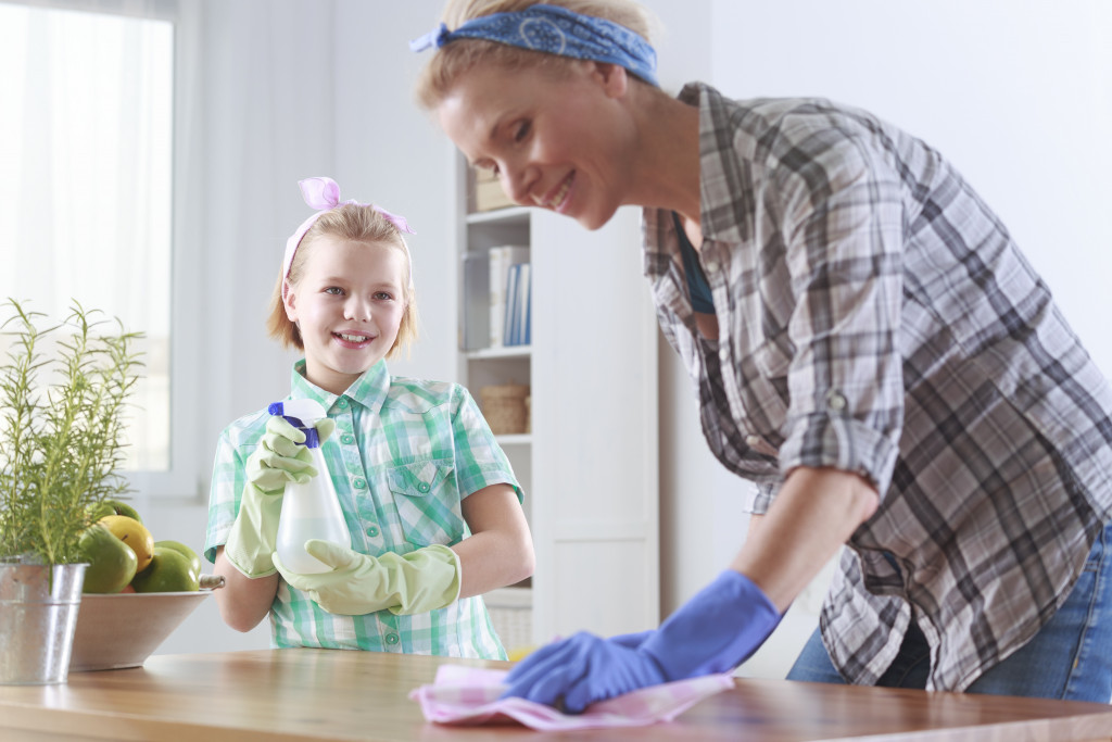 mother cleaning house with daughter